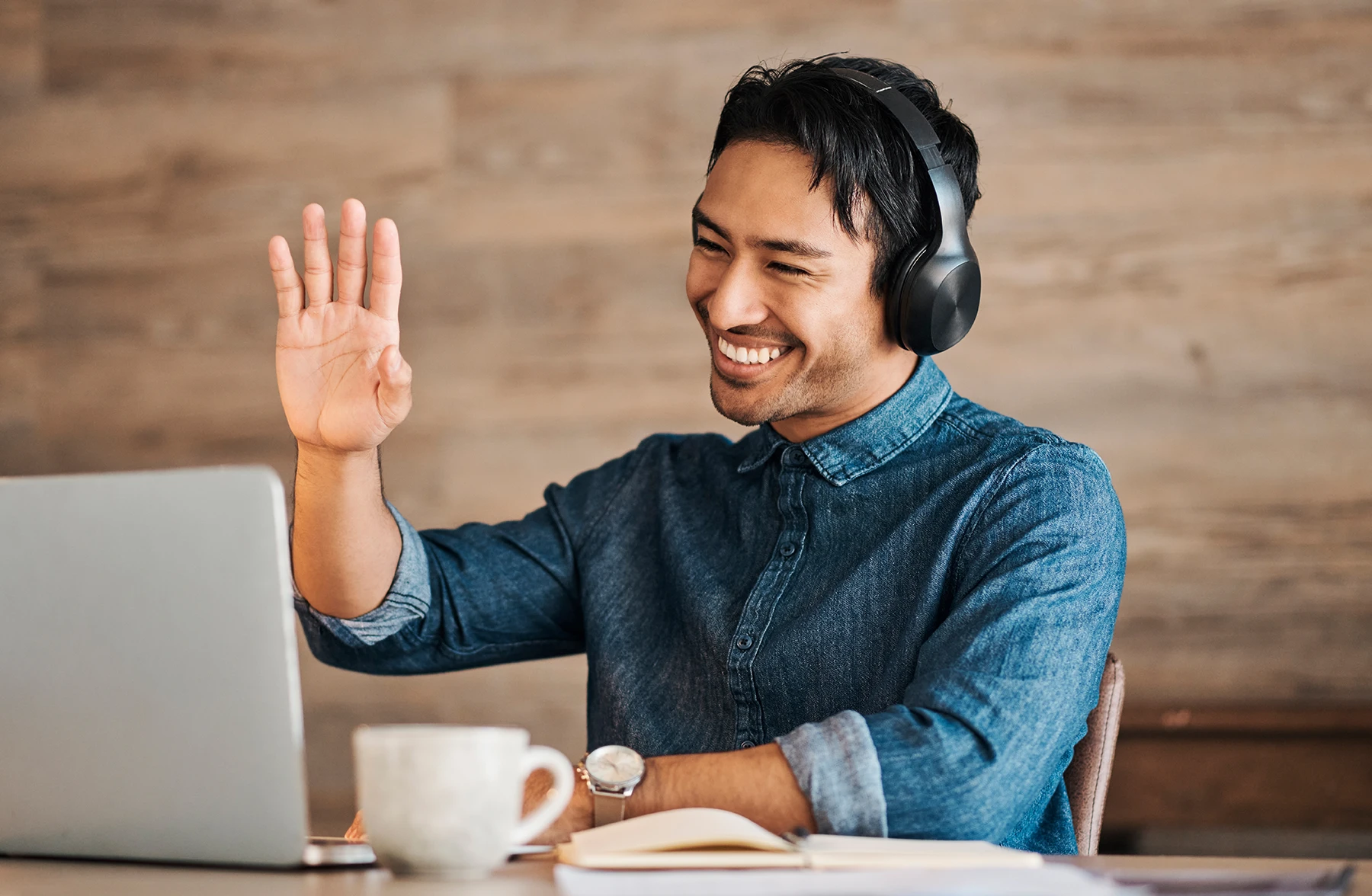 This is an image of a tutor waving at a student on a laptop screen.